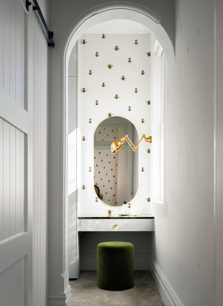 In this serene setting, picture a small, simple image of a bee in wallpaper. Its subtle presence adds a touch of nature to the clean, white bathroom gold light. Pamment Projects Building Company,