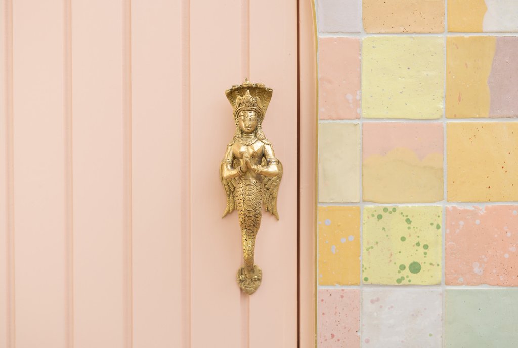 Our Foreman made The Pink Gate with a solid brass mermaid angel handle painted in apricot-pink to match the new pool fence inside. Surrounding the gate are hundreds of glazed ceramic tiles, handmade in Marrakesh by the owner's sister to match the interior color palette.